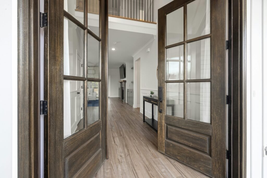 Spacious entrance with elegant wooden double doors leading to a modern interior.