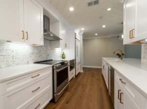 Sleek contemporary kitchen design featuring white cabinetry and stainless steel appliances.